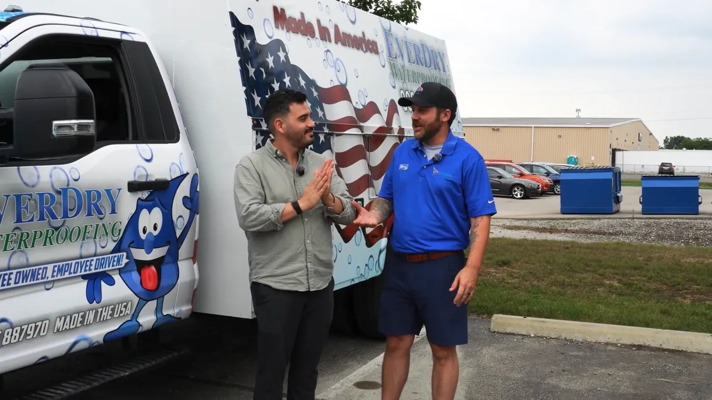 A Localizr strategist on a client job site, talking with a crew member in front of their branded work truck